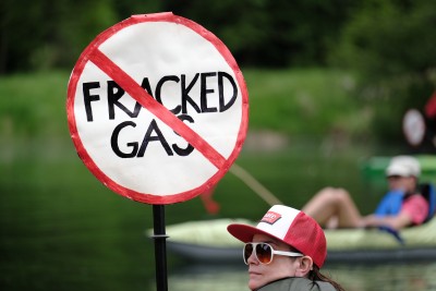 Person holding a "No Fracked Gas" protest sign