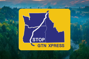 "Stop GTN Xpress" sticker overlaying Columbia River scenic photo